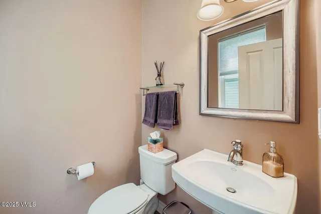 a bathroom with a toilet a sink and mirror