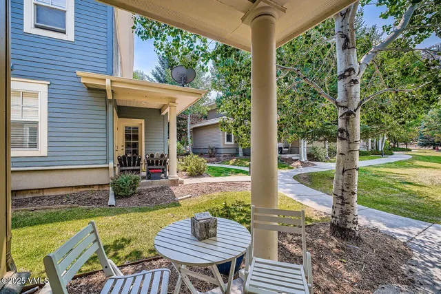 a view of a patio with table and chairs potted plants and large tree