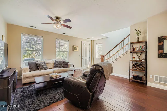 a living room with furniture and a wooden floor