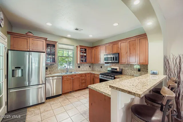 a kitchen with stainless steel appliances granite countertop a refrigerator stove microwave and sink