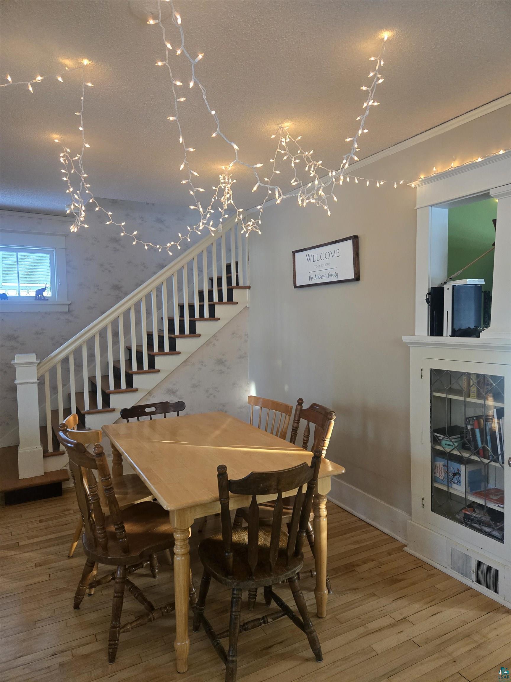 26 3rd Street Proctor, MN 55810 - Photo 23 of 26 Dining area with stairway, light wood-style flooring, wallpapered walls, and a textured ceiling