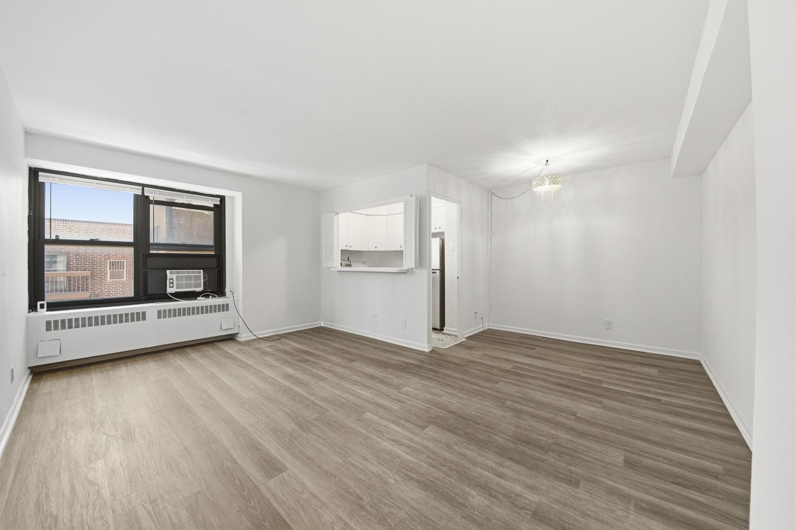 6118 North Sheridan Road, Unit 506 Chicago, IL 60660 - Photo 5 of 13 an empty room with wooden floor and windows