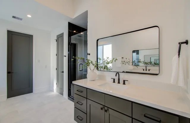 a spacious bathroom with a double vanity sink shower and mirror