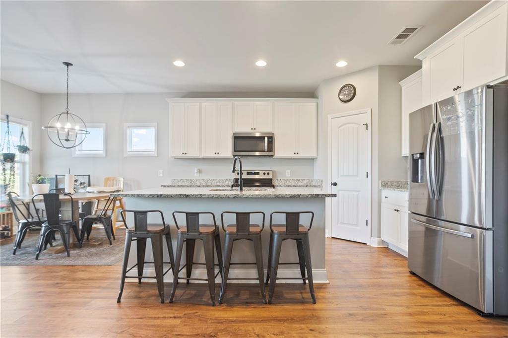 64 Neal Little Road Carnesville, GA 30521 - Photo 5 of 17 a kitchen with stainless steel appliances granite countertop a dining table chairs refrigerator and microwave
