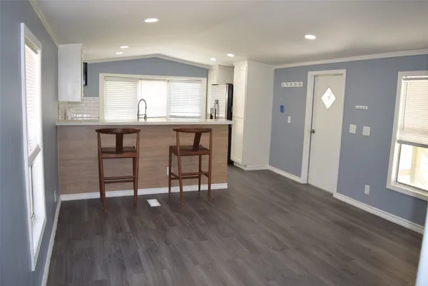 a kitchen with granite countertop wooden floors and white cabinets