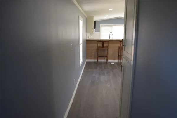 a view of a hallway and a sink and a window in a bathroom