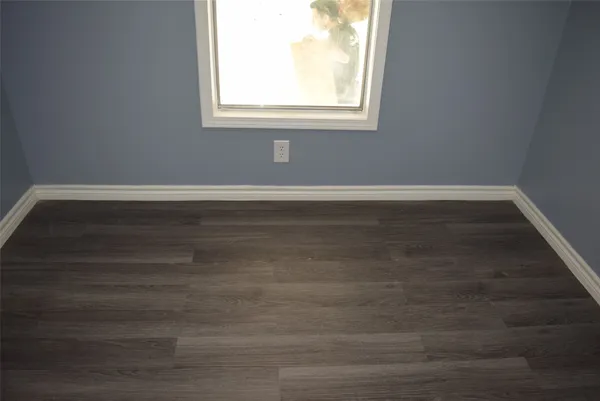 a view of a small space with wooden floor and a window