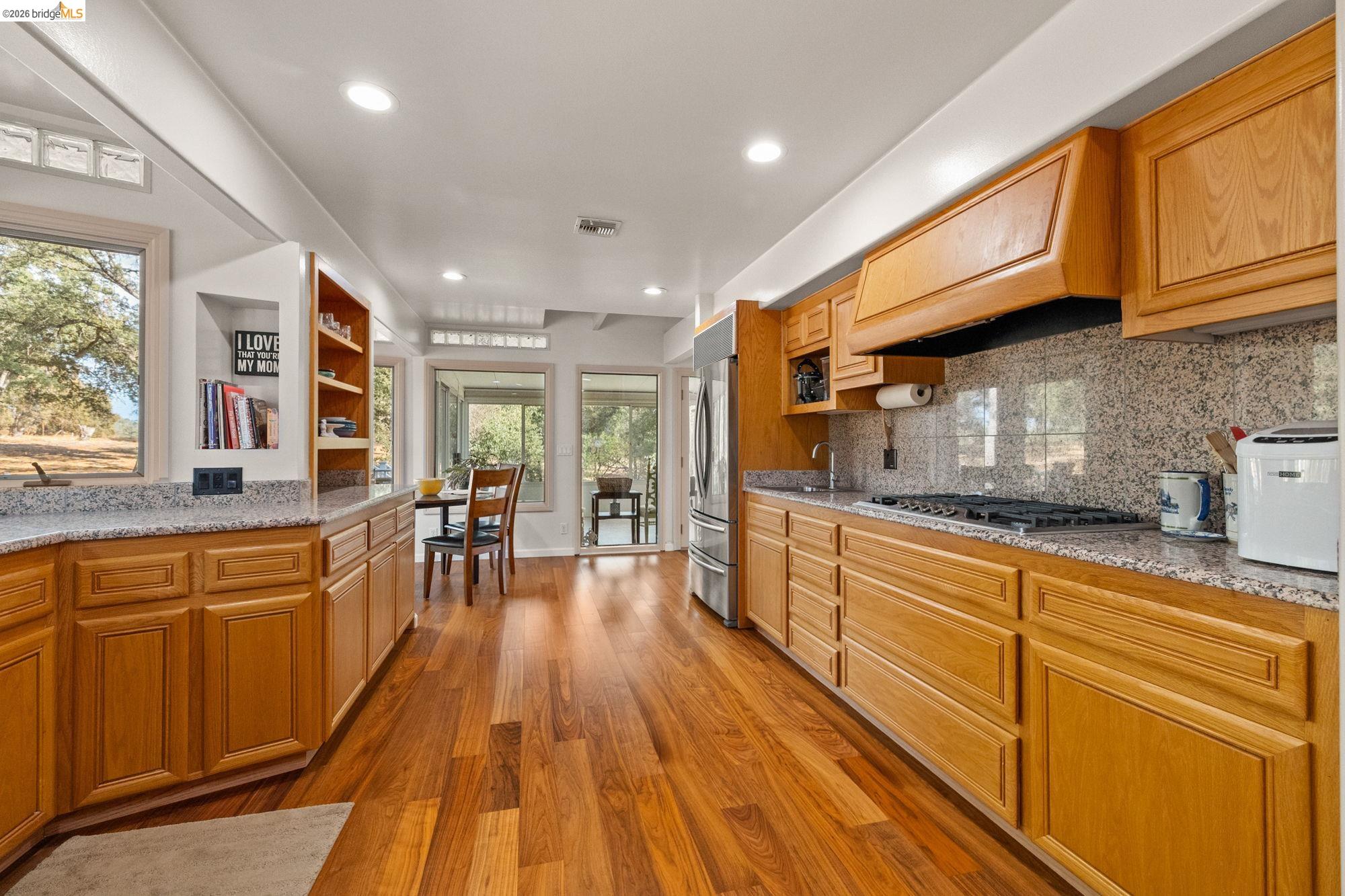 10566 Thistle Down Road Jamestown, CA 95327 - Photo 19 of 53 Kitchen featuring light stone countertops, open shelves, light wood-style flooring, backsplash, and recessed lighting
