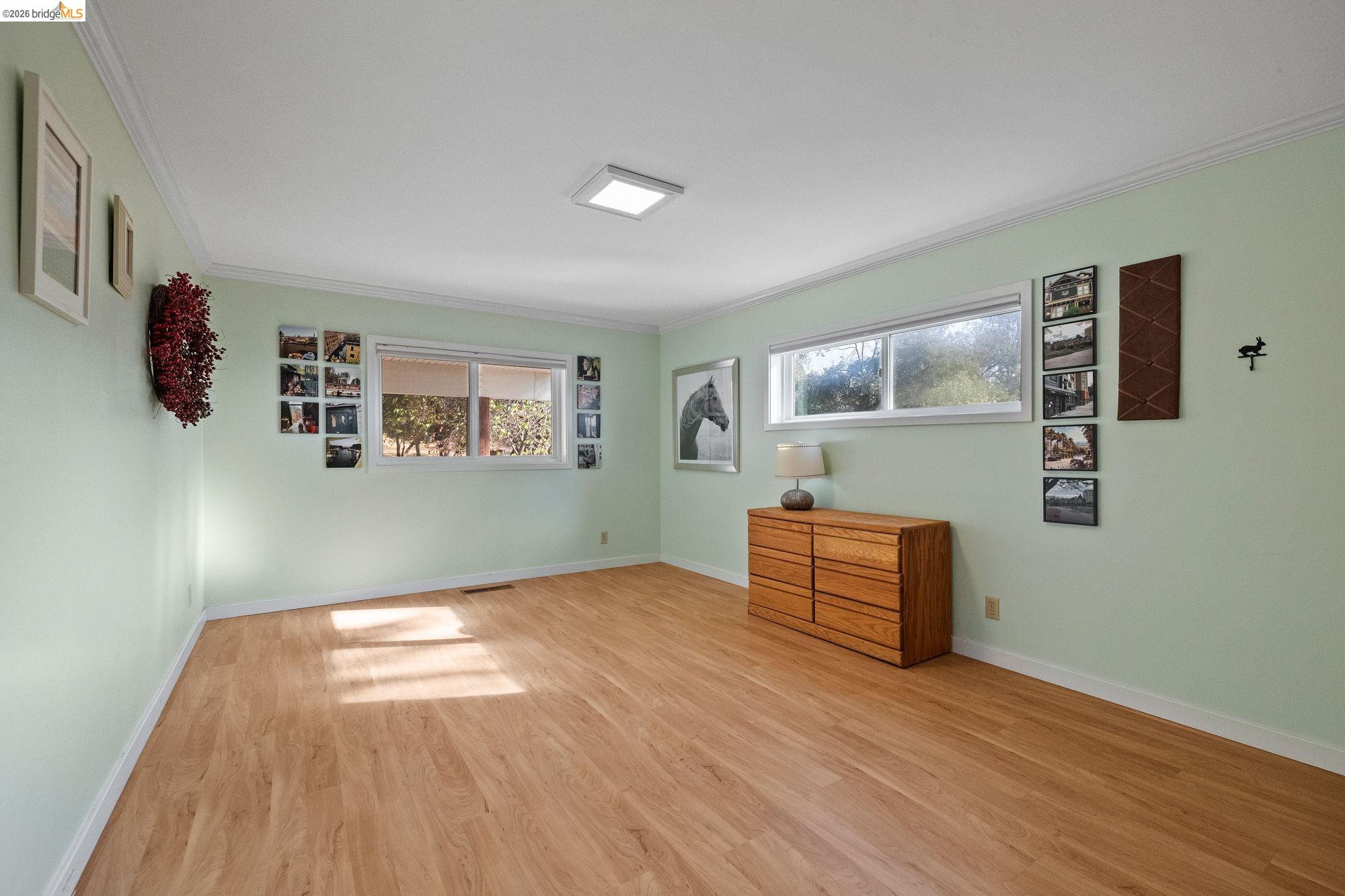 10566 Thistle Down Road Jamestown, CA 95327 - Photo 30 of 53 Unfurnished bedroom featuring light wood-style floors, multiple windows, and crown molding