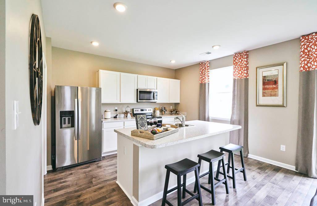 62 Buttercup Circle Elkton, MD 21921 - Photo 6 of 36 a kitchen with stainless steel appliances a dining table chairs refrigerator and sink