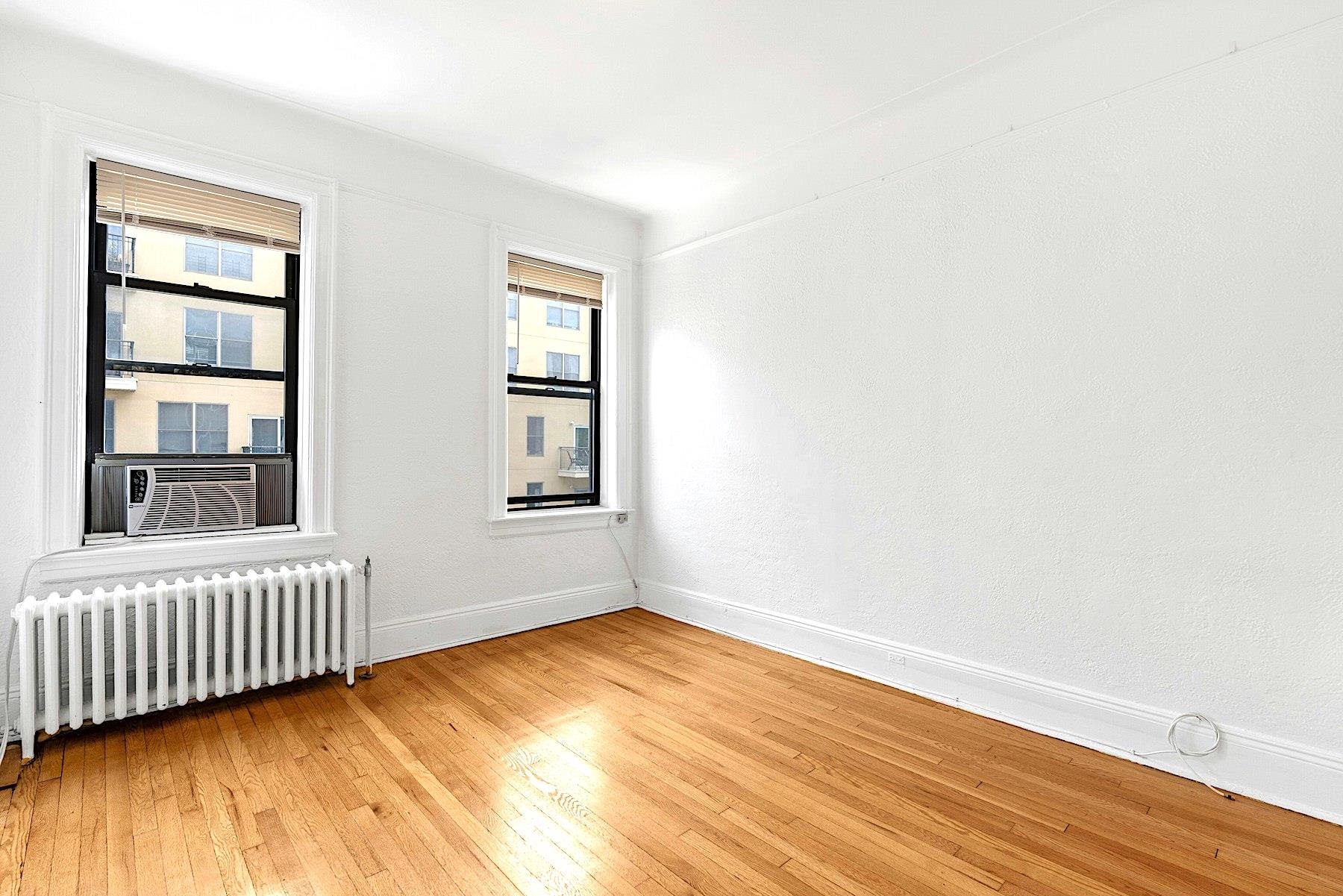79 Madison Street, Unit 4A Hoboken, NJ 07030 - Photo 6 of 17 an empty room with a window and wooden floor