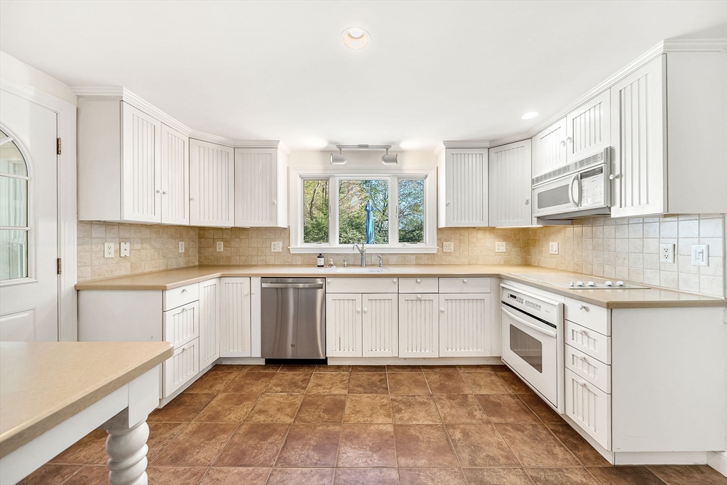 10 Bennett Road Wayland, MA 01778 - Photo 12 of 32 a kitchen with granite countertop cabinets stainless steel appliances a sink and a window