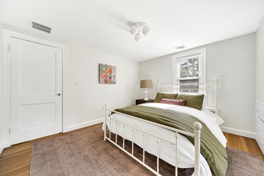10 Bennett Road Wayland, MA 01778 - Photo 26 of 32 a bedroom with a bed and a chandelier