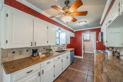 a kitchen with stainless steel appliances granite countertop a sink a stove counter space and cabinets
