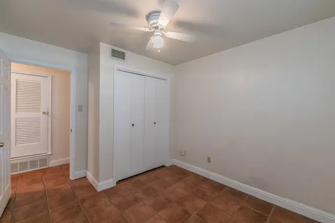 an empty room with a ceiling fan and a window