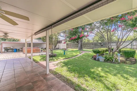 a view of a house with backyard and sitting area