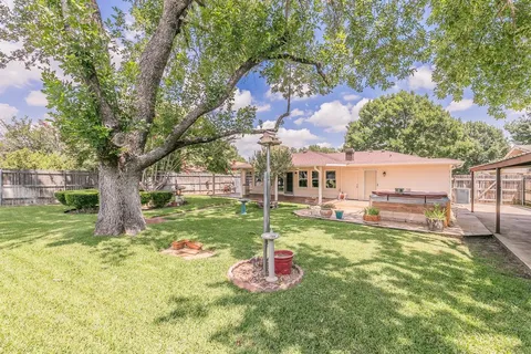 a backyard of a house with table and chairs