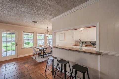 a dining room with furniture and a large window