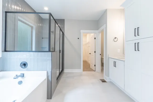 a bathroom with a tub sink and mirror
