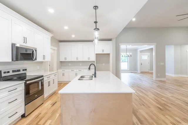 a large kitchen with kitchen island a sink stainless steel appliances and cabinets