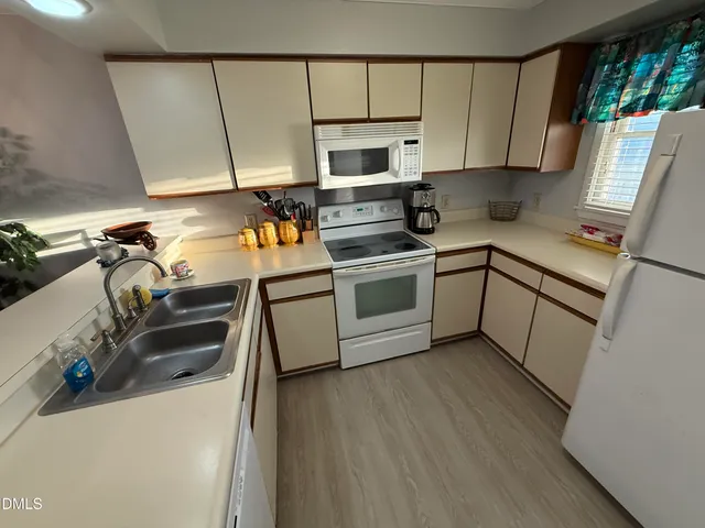 a kitchen with a sink a microwave and cabinets