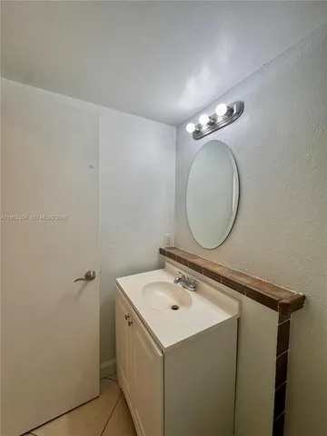 a utility room with a sink a mirror and vanity