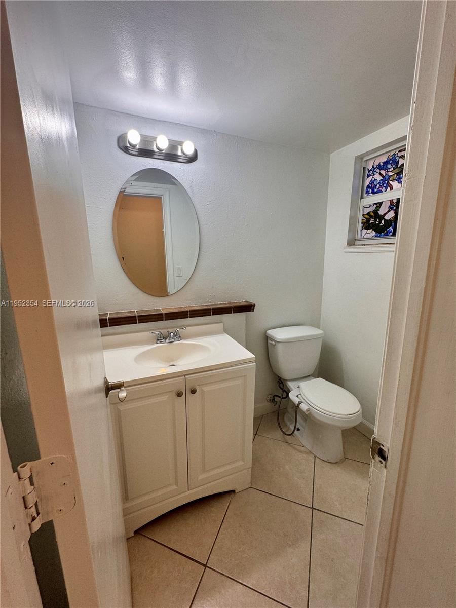 4879 North Hemingway Circle Margate, FL 33063 - Photo 15 of 44 a bathroom with a granite countertop toilet sink and mirror