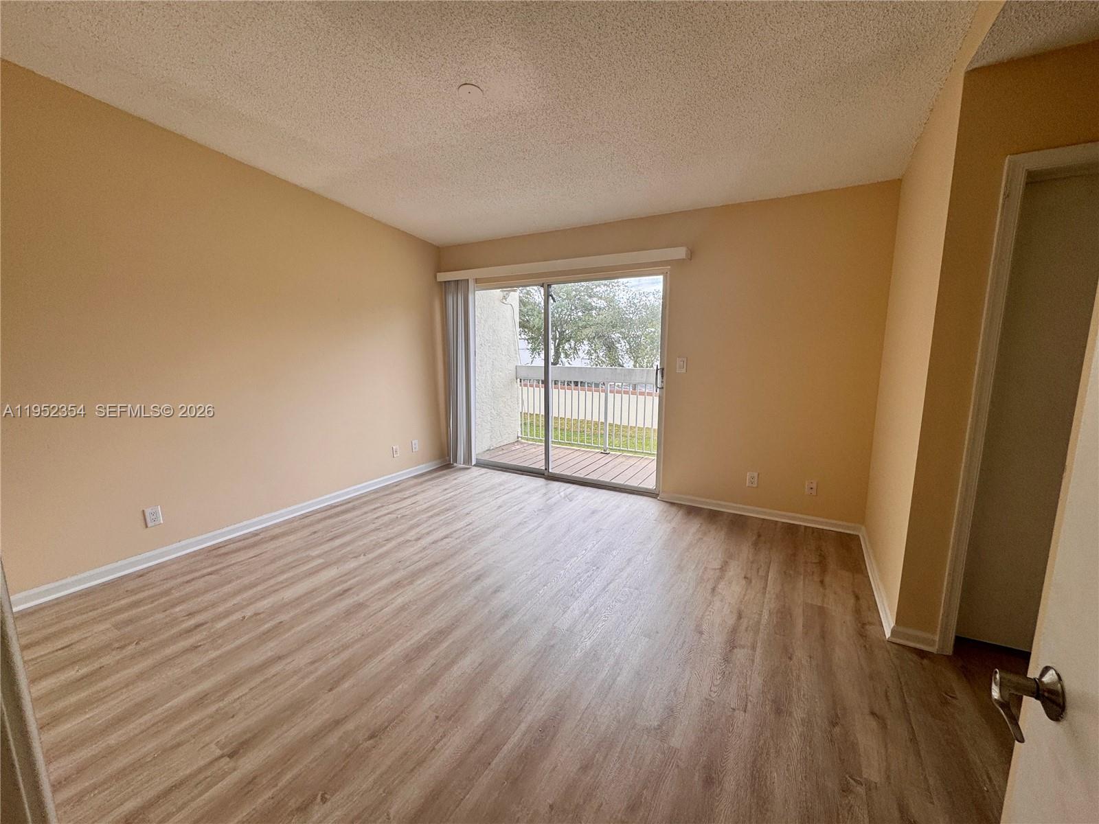 4879 North Hemingway Circle Margate, FL 33063 - Photo 26 of 44 an empty room with wooden floor and windows