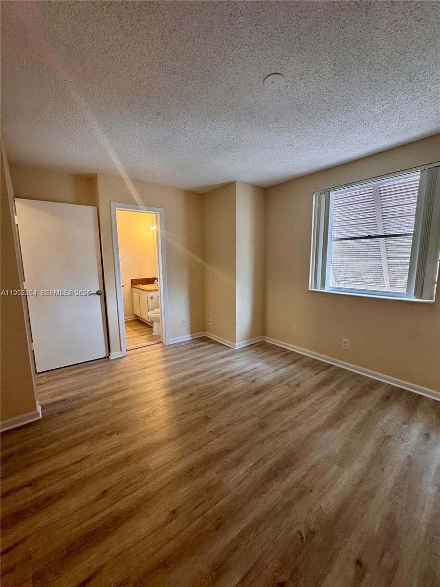 4879 North Hemingway Circle Margate, FL 33063 - Photo 29 of 44 an empty room with wooden floor and windows