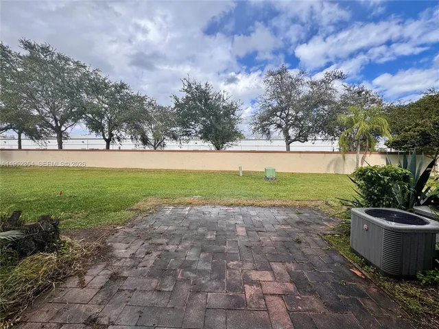 a view of a garden with a fountain in the background