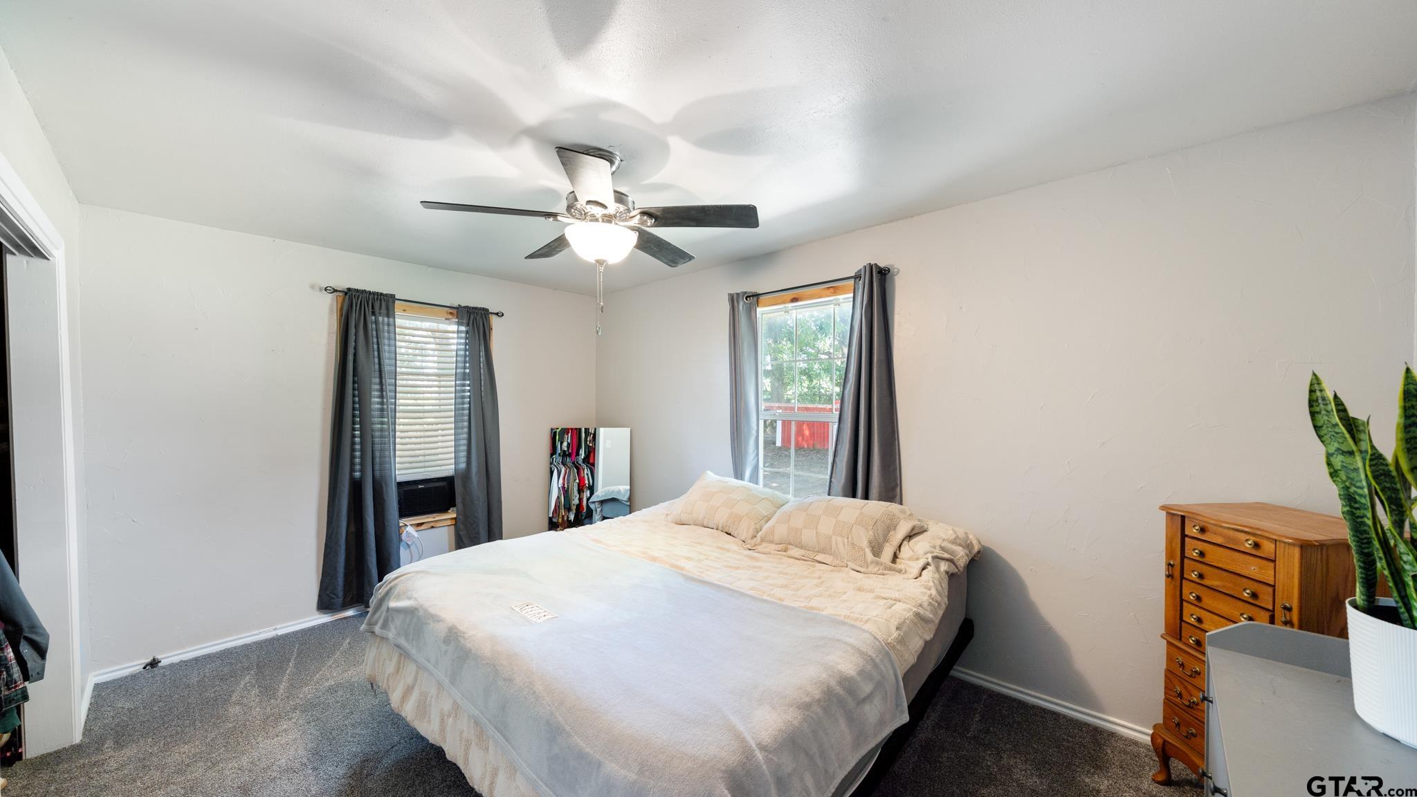 29080 Highway 19 Athens, TX 75752 - Photo 14 of 30 a spacious bedroom with a bed and a chandelier