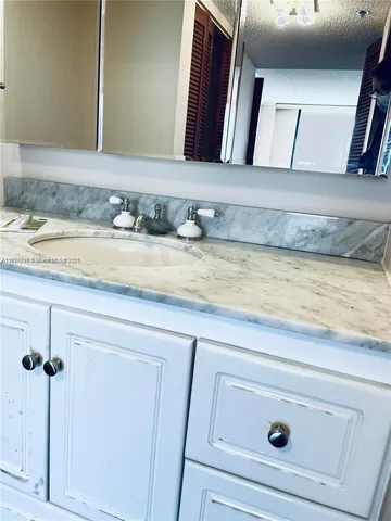 a bathroom with a granite countertop sink and vanity