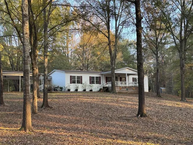 a view of a yard in front of a house with large trees