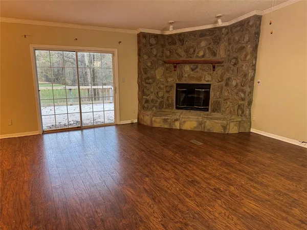 an empty room with wooden floor and fireplace