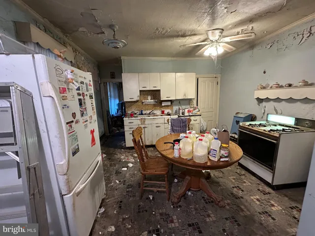 a kitchen with stainless steel appliances a stove a refrigerator and a dining table