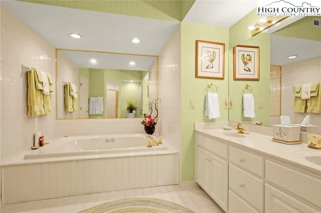 a bathroom with a tub sink and mirror