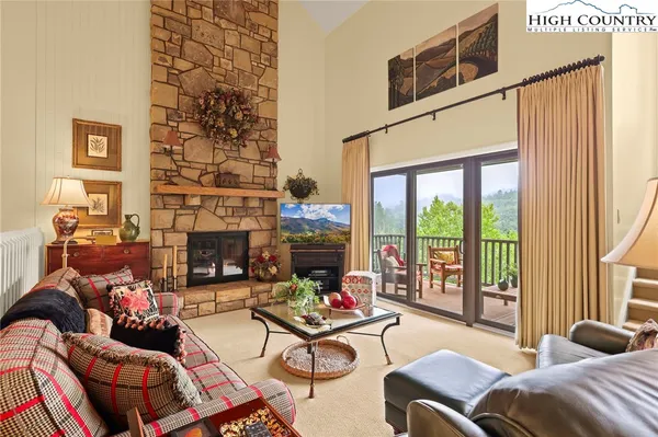 a living room with fireplace furniture and a large window