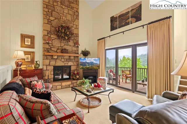 a living room with fireplace furniture and a large window