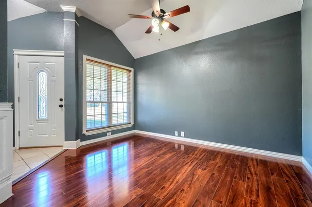 a view of empty room with wooden floor and fireplace