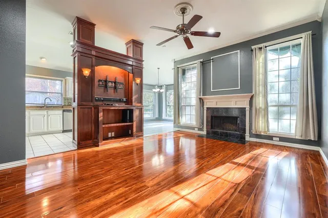 a view of empty room with wooden floor and window