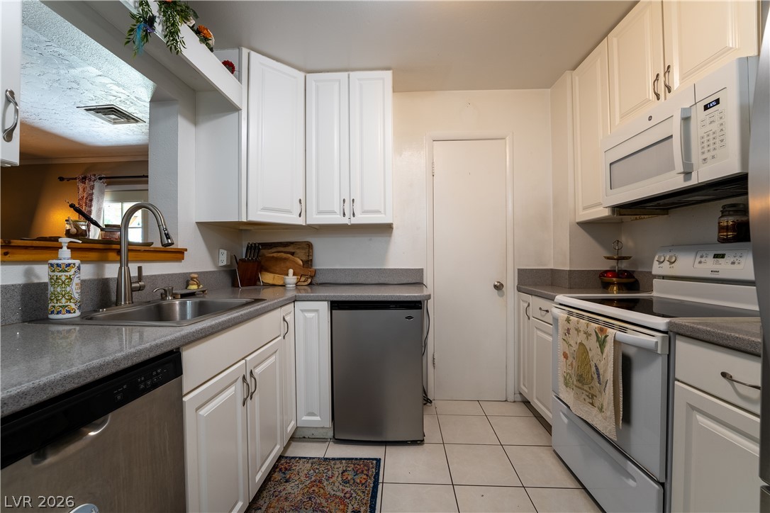 1324 Appaloosa Road Boulder City, NV 89005 - Photo 9 of 42 Functional kitchen with ample cabinet space and a convenient pass-through window.