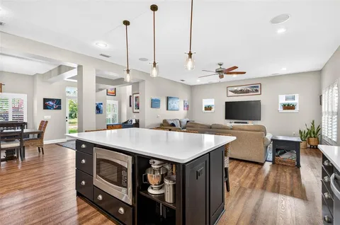 a large kitchen with kitchen island a stove a sink a center island and couches