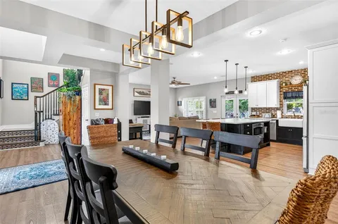 a kitchen with granite countertop a table chairs stainless steel appliances and wooden floor