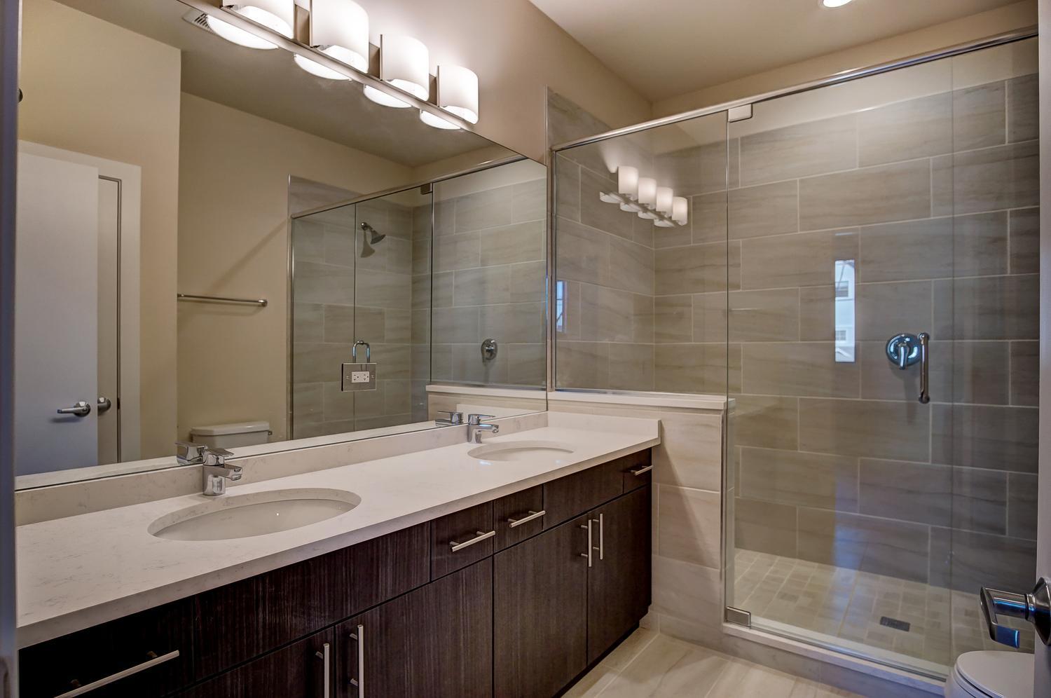 2532 West Addison Street, Unit 1W Chicago, IL 60618 - Photo 9 of 24 a bathroom with a double vanity sink mirror and shower