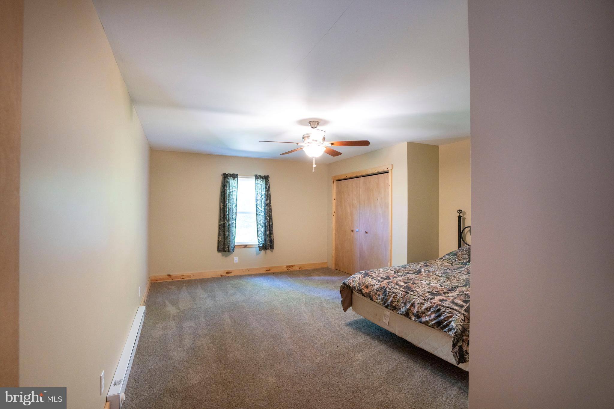 385 Elk Creek Road Aaronsburg, PA 16820 - Photo 42 of 71 a bedroom with a bed and a chandelier