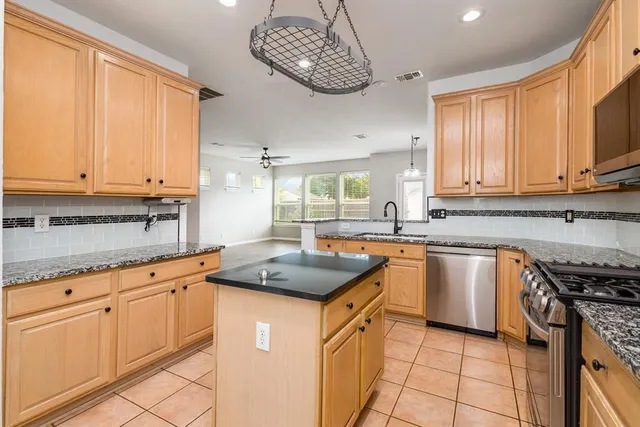 a kitchen with stainless steel appliances granite countertop a sink stove and cabinets