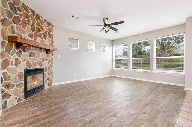 a view of an empty room with a fireplace and a window