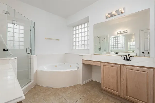 a large white bathroom with a large tub sink and mirror