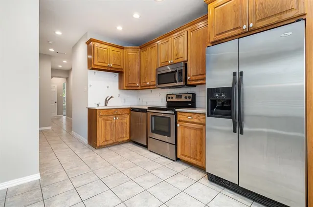 a kitchen with stainless steel appliances granite countertop a refrigerator a sink and a stove