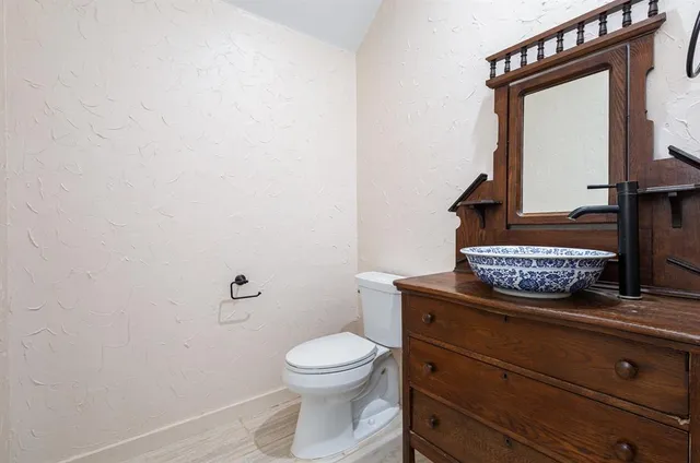 a bathroom with a toilet a sink and mirror